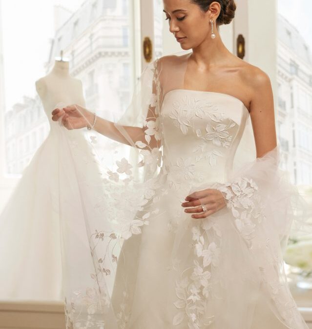 Vestido de noiva de duas peças, de corte evasé e estilo romântico. Realizado em cetim de seda e tule pintado à mão. Com decote caicai, saia tulipa. Caua removível de tule. Modelo Rosa Clará Couture exclusivo.