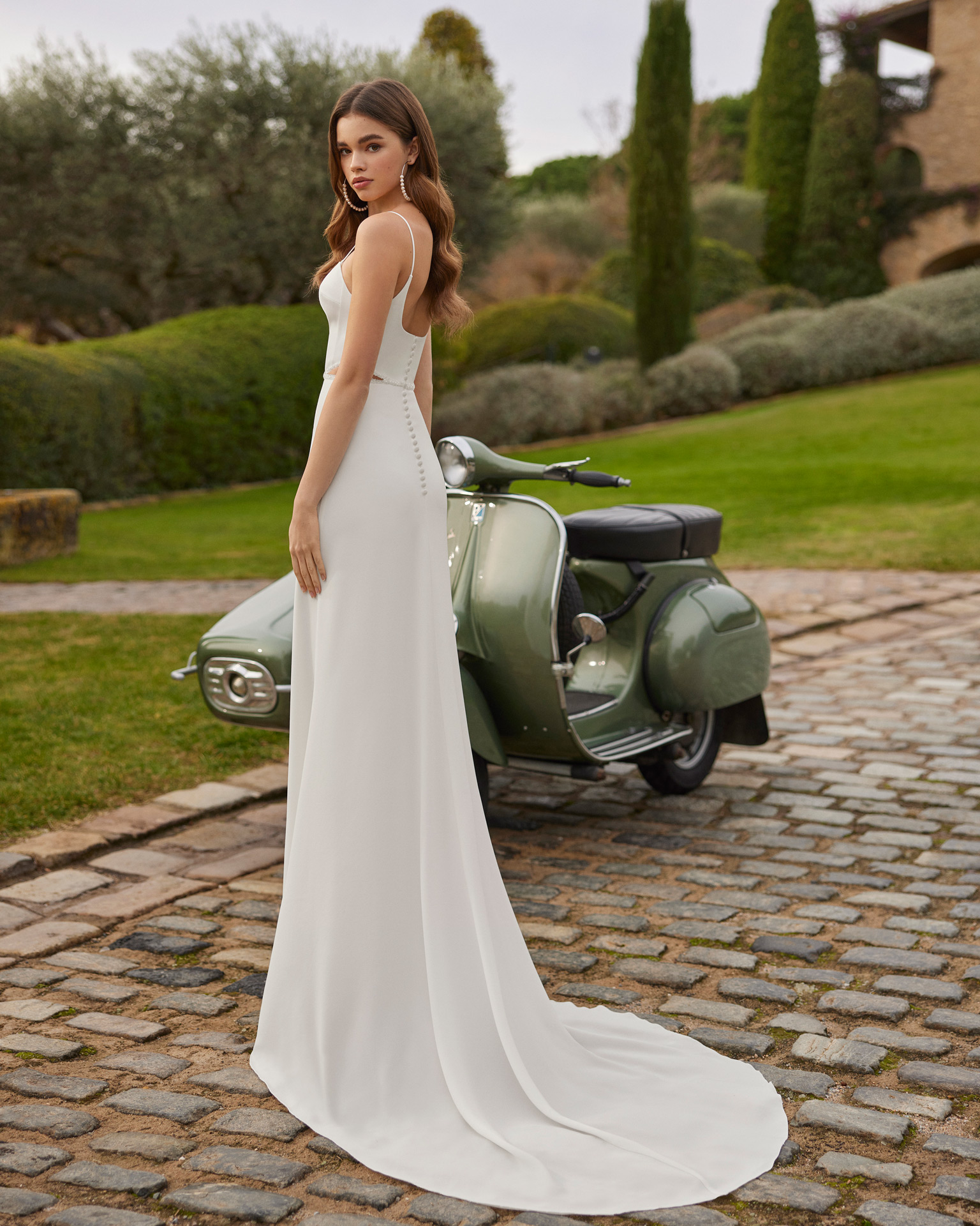 Vestido de noiva comprido, de corte reto e estilo simples e fluido. Elaborado com crepe, completa-se com um decote quadrado, costas abotoadas e alças.